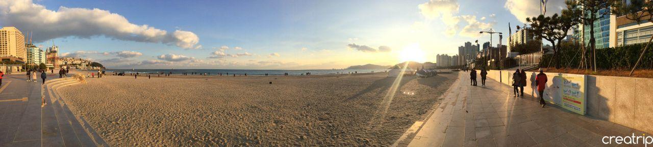 A panoramic view of Haeundae Beach during sunset, capturing the beauty of Busan's coastal horizon.